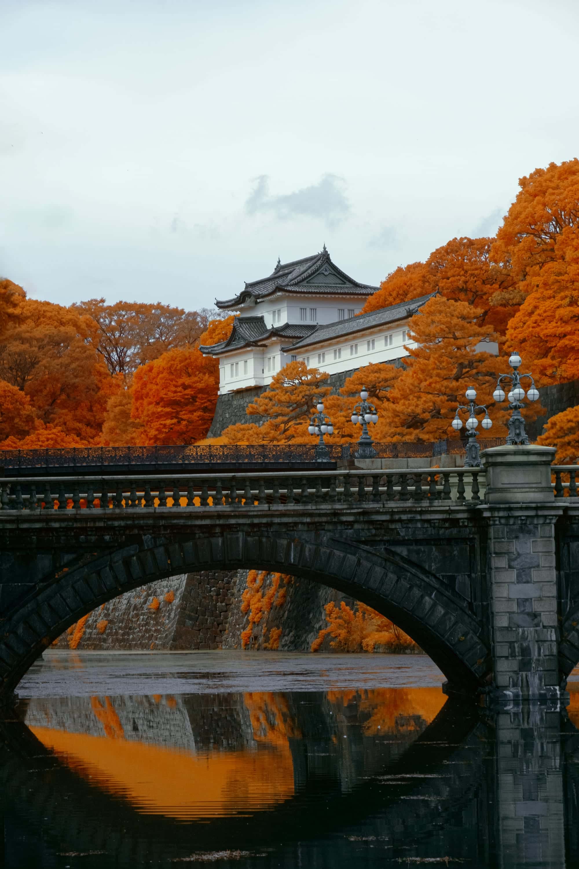 The Nijubashi bridge and the white keep of the Imperial Palace, orange canopy doubled in the moat